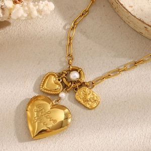Gold-plated heart locket necklace with pearls on a sandy beach with corals