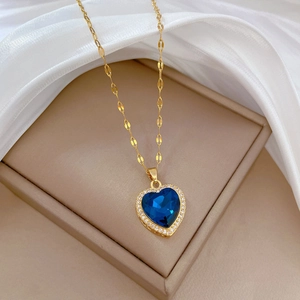 Luxurious gold necklace featuring a heart-shaped blue gemstone pendant with crystal halo