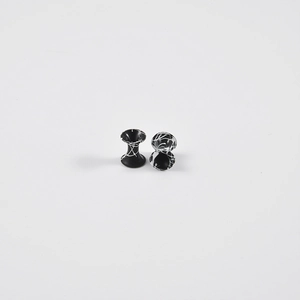 Detail view of double flare ear gauges with white marble texture on black background