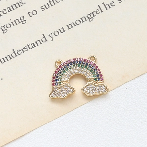 Macro shot of gold-plated rainbow pendant with multicolored stones on vintage book page