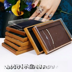 Close-up of stacked bamboo jewelry organizers with acrylic lids and velvet liners