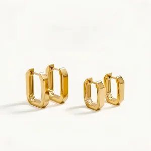 Macro detail of high-polish gold geometric rectangular earrings in two different sizes