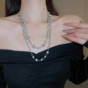 Detail view of double-layered Y2K necklace with silver grey pearls and star pendants