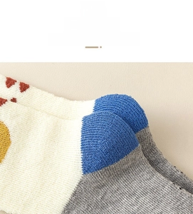 Detailed close-up of knitted baby sock heel featuring colorful polka dot patterns