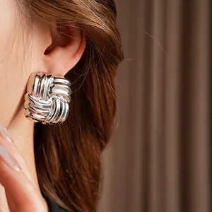 Minimalist square woven pattern stud earrings with vintage metallic texture on model