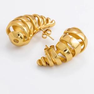 Macro view of golden hollow spiral stud earrings with polished stainless steel finish