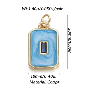 Detailed view of a gold pendant with light blue enamel and dark blue gemstone inlay