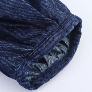 Makroansicht der dunkelblauen Denim-Stofftextur und präzise Nahtdetails am Ärmel