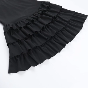 Detailansicht der gestuften Rüschen an einem schwarzen trägerlosen Minikleid mit Textur