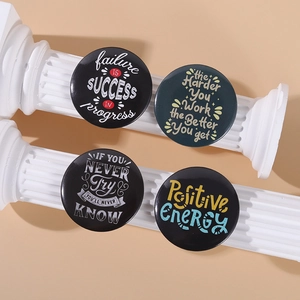 Detail of four black round tinplate badges with inspirational quotes on roman columns