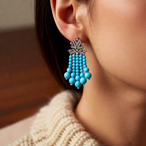 Détail de boucles d'oreilles en argent avec glands turquoise bleus et cristaux brillants