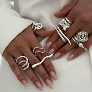 Detail shot of multiple silver irregular rings including infinity and wave designs