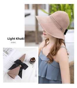 Detail of khaki straw sun hat with breathable knit texture and black bow decoration