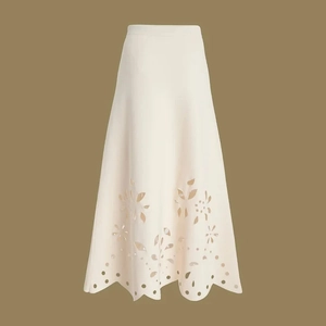 Close-up of high-waist white skirt with hollow floral embroidery and scalloped hemline