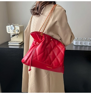 Detail view of red quilted leather texture and golden chain strap on shoulder bag