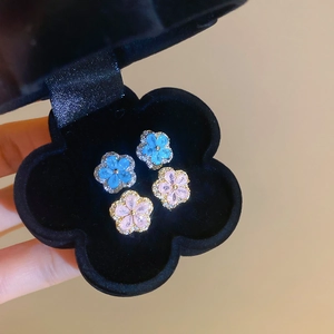 Macro shot of pink and blue zircon flower earrings in a black velvet jewelry box