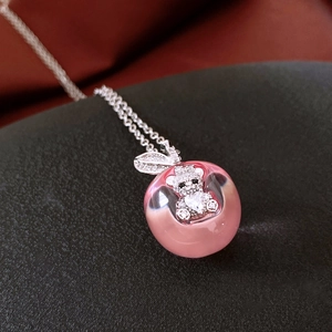 Detailed view of a pink apple pendant featuring a silver bear charm with cubic zirconia