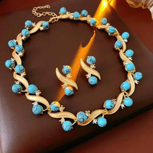 Macro shot of vintage gold necklace and turquoise earrings with rhinestones detail
