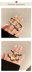 Detail of brushed metal bar and heart charms on black high-elastic hair ties