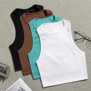 Slim fit nylon yoga tank tops in black, brown, blue and white stacked on a table