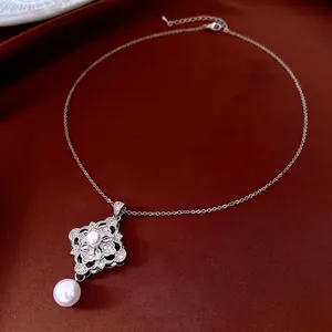 Elegant silver flower necklace with white pearls and zircons on deep red silk fabric