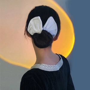 Détail du nœud blanc pour chignon avec un arrière-plan chaud effet coucher de soleil