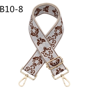 Close-up of vintage ethnic floral jacquard bag strap with gold metal lobster clasps