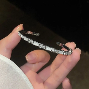 Zilveren slangenarmband met glinsterende zirkonia en geometrische accenten van parelmoer