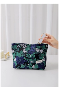 Detail of vintage floral jacquard pouch with metal zipper showing lipstick storage