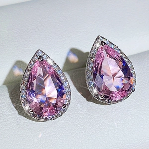 Close-up of pear-cut pink zircon earrings with halo stones in silver-tone finish