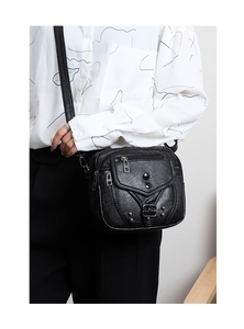 Détail du sac bandoulière en cuir souple noir avec fermetures éclair et rivets