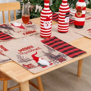 Christmas table runner and wine bottle covers with gnome and reindeer patterns on wood table