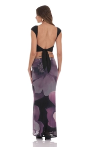 Detail of a backless black crop top with lace-up ties and a floral maxi skirt