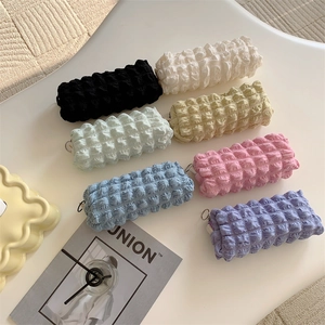 Close-up of fluffy bubble textured pouches in seven pastel colors for stationery or makeup