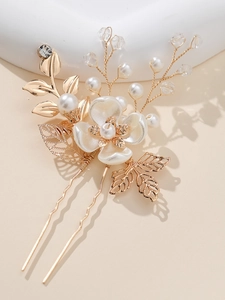 Detailed macro view of white floral petals and golden metal leaves on a bridal hair pin
