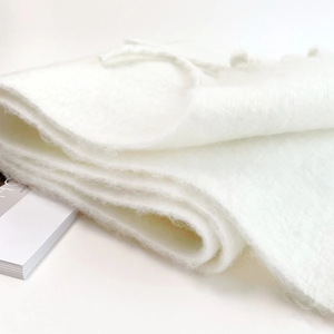 Close-up of thick white mohair scarf showing soft fluffy texture and plush fibers