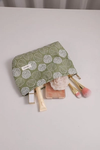 Detail of green floral embroidered canvas makeup bag showing storage space and zipper