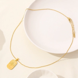 Macro shot of 18k gold plated stainless steel rectangle pendant with sunburst engraving