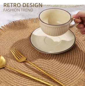 Dettaglio del set da caffè in ceramica retrò su tovaglietta intrecciata e posate dorate