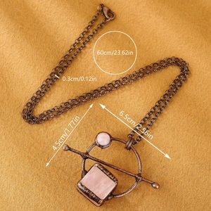 Vintage bronze necklace with natural pink crystals and geometric square pendant on yellow fabric