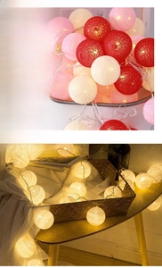 Detail of warm white cotton ball LED string lights with soft woven texture on wood