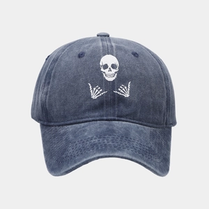 Close-up of vintage navy blue denim baseball cap featuring white skull and crossbones print