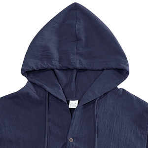 Dettaglio ravvicinato del cappuccio in lino blu navy e dell'etichetta con taglia M e texture