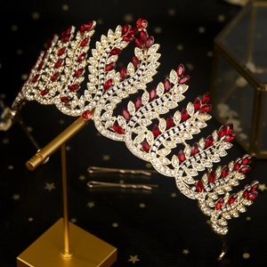 Detailed close-up of Baroque crown with gold leaf design and red marquise rhinestones