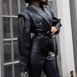 Détail de la veste en simili cuir noir avec ceinture et manches à lacets