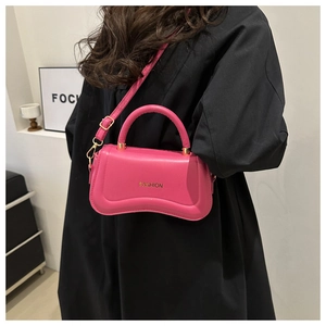Détail du sac à main fuchsia en cuir avec boucles dorées et lettrage logo mode