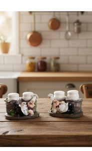 Detail of creative resin chef figurines holding ceramic salt and pepper shakers on wood
