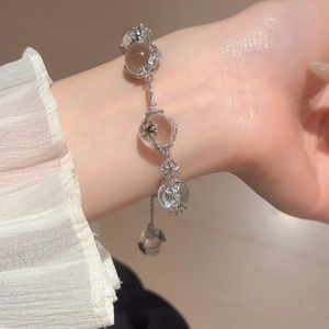 Detailed view of beaded snowflake bracelet with silver charms on woman's wrist