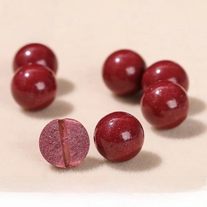 Macro shot of red cinnabar round beads showing a cross-section of internal mineral structure