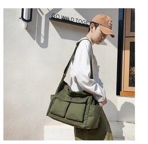 Close-up of military green canvas messenger bag with large functional cargo pockets
